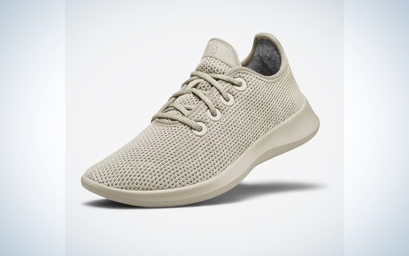 A pair of grey AllBirds sneakers on a blue and white background