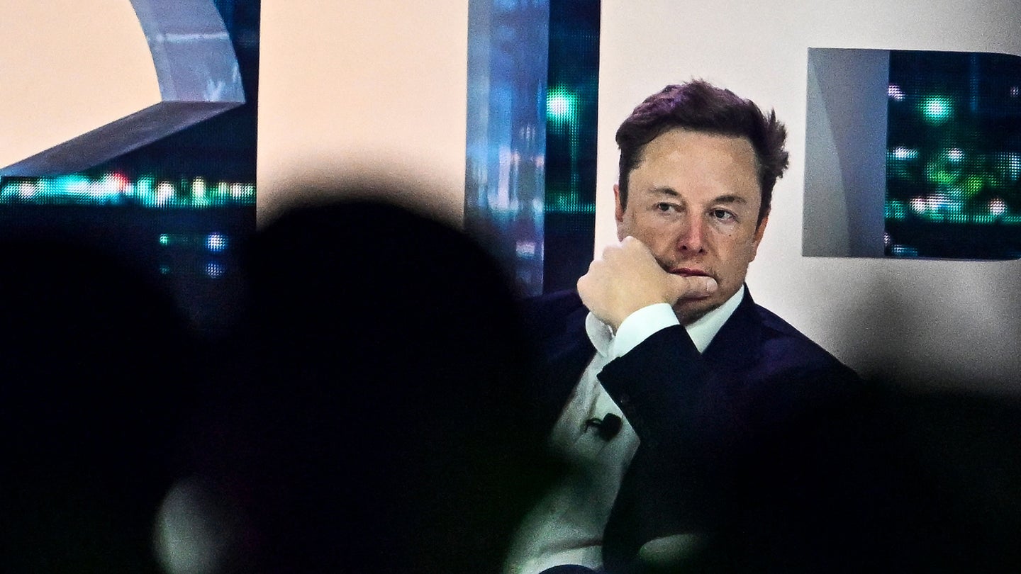 Elon Musk in meeting wearing suit