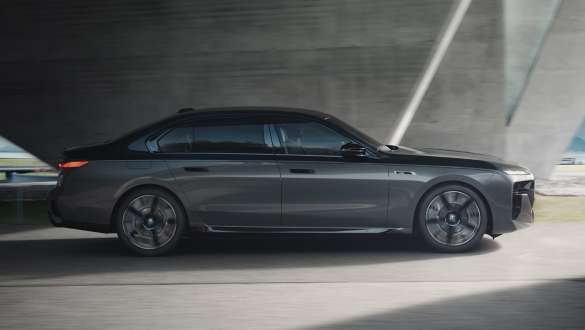 Electric range BMW M760e xDrive Sedan G70 M Performance package Electric range BMW M760e xDrive Sedan G70 M Performance package BMW Individual two-tone Black Sapphire metallic paintwork BMW Individual Dravite Grey metallic side view driving on the street