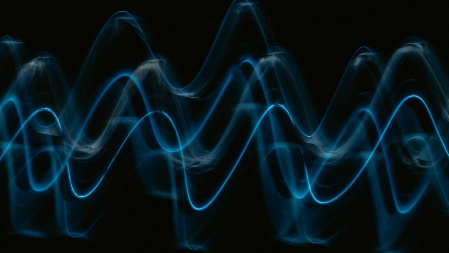 Blue sine waves on a black background. Sine waves, like these, are a way to envision how sound works.